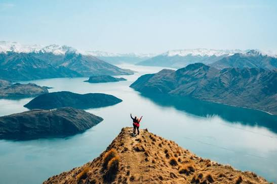 Solo hiker on summit with open arms