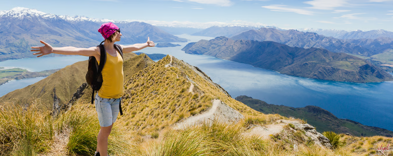Joyful traveler on mountain ridge